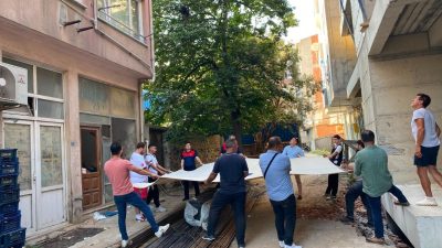 Sinop’ta bir binanın 5. katındaki dairenin penceresine çıkan kadın, ekiplerin